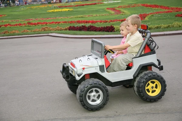 Niño y niña en coche de juguete — Foto de Stock