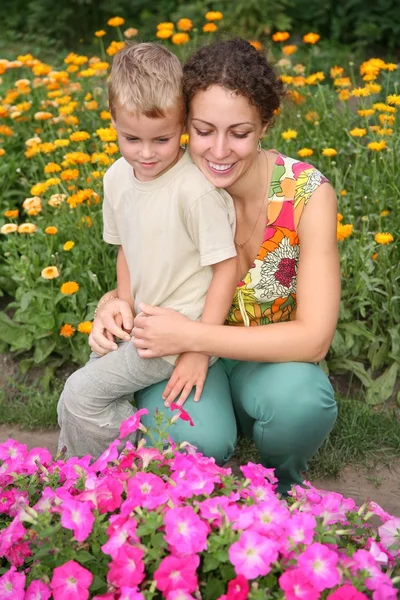 Mother and son look on flowers — Stock Photo, Image