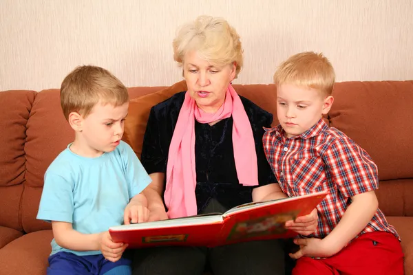 Бабушка и внуки прочли книгу — стоковое фото