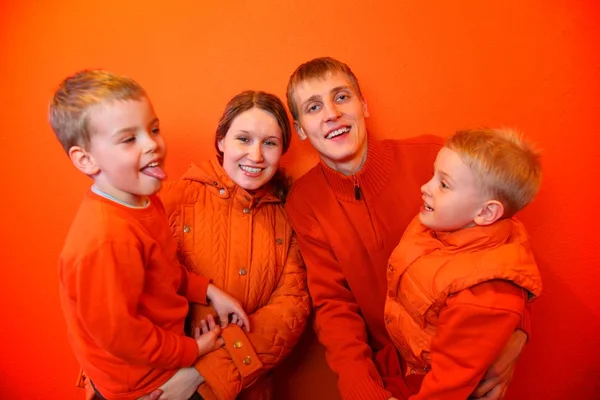 Família juntos em um fundo laranja — Fotografia de Stock