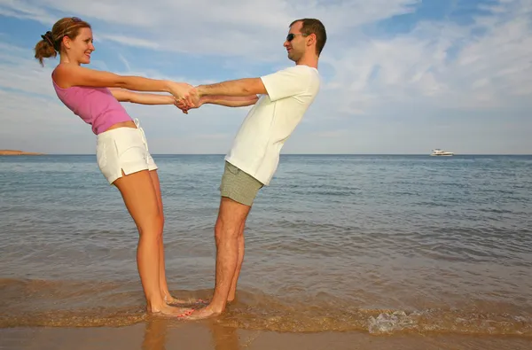 Άνδρας και γυναίκα να σταθεί σε μια παραλία — Φωτογραφία Αρχείου