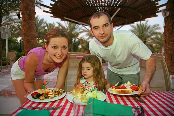 Familie hinter einem kleinen Restauranttisch — Stockfoto