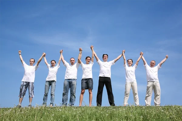 Seven friends in white shirts have waved hands — Stock Photo, Image