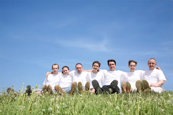 Des amis en T-short blanc se reposent sur une herbe — Photo