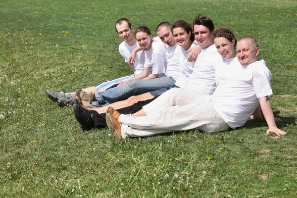 Sedm přátelé v bílým t šortky mají odpočinek trávě — Stock fotografie