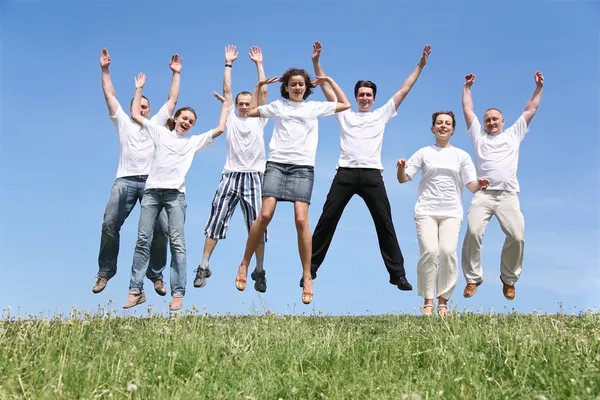 Sept amis en T-short blanc sont dans un saut — Photo