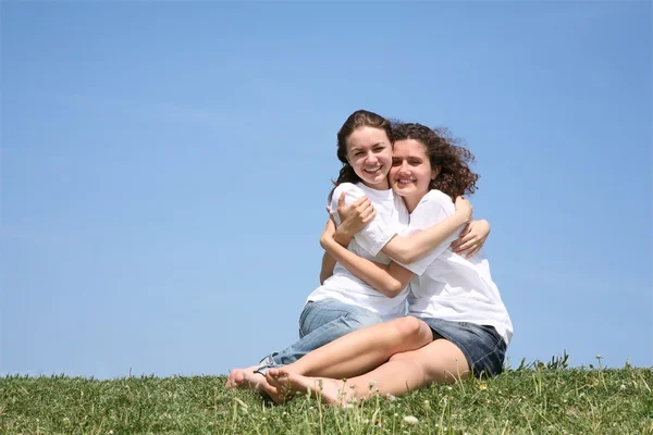 Two girlfriends in white T-shorts embrace — Stock Photo, Image
