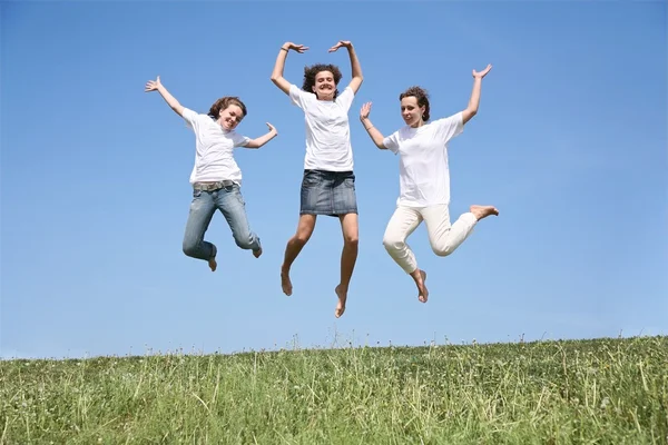 Three girlfriends in white T-shorts jump simultaneously — Stock Photo, Image