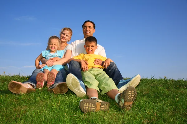Sitter familj gräs himmel — Stockfoto