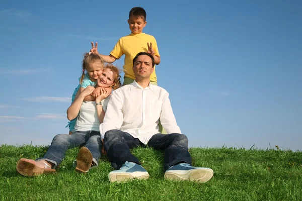 Familjen sitter gräs — Stockfoto