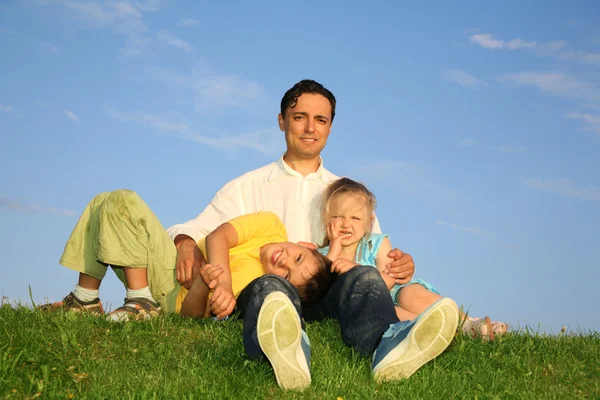 Отец с детьми на траве — стоковое фото