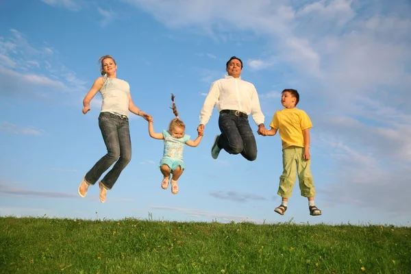 Familie gras lucht springen — Stockfoto