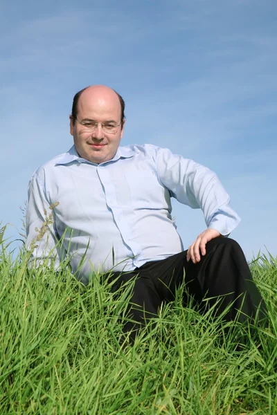 Dicker Mann sitzt im Gras — Stockfoto