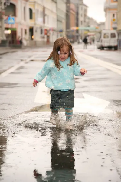 Girl on street in puddle — Stock Photo, Image