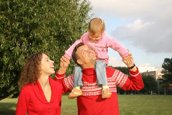 Rodina s dcerou, která sedí na ramenou otce — Stock fotografie