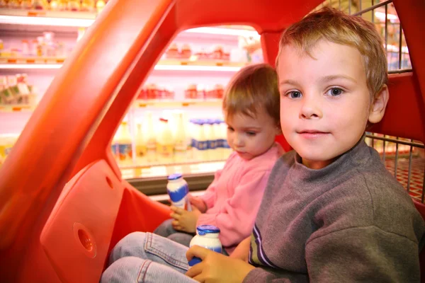 Kinderen in de speelgoed auto in de supermarkt — Stockfoto