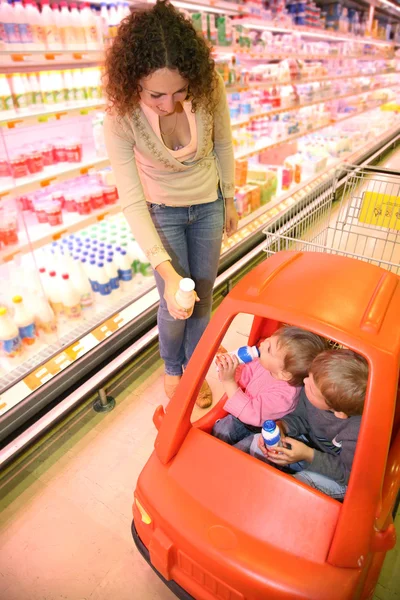 Мама с детьми в супермаркете — стоковое фото