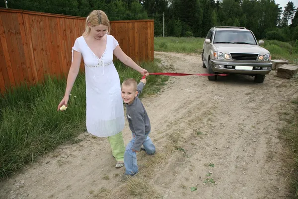 Mother with the son they pull automobile on the rope — Stock Photo, Image