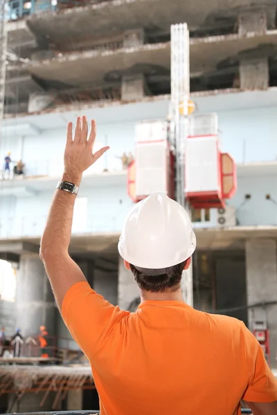 Behind worker in the helmet with hand up — Stock Photo, Image