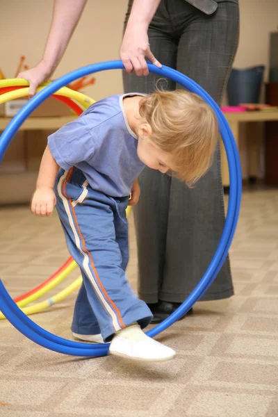 Baby paly with hoop with mentor — Stock Photo, Image