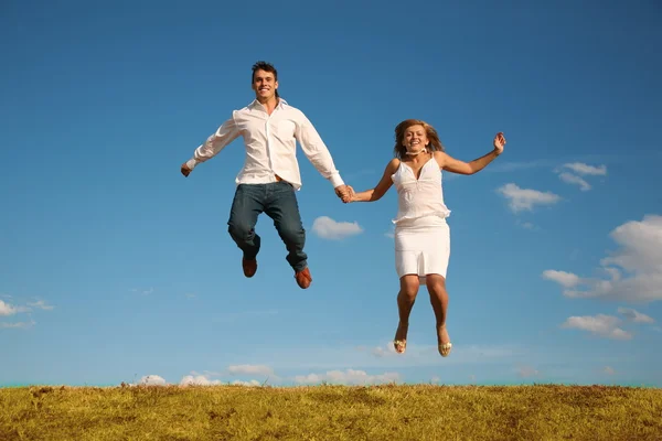 Homem e mulher pulando no prado — Fotografia de Stock