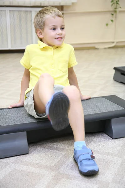 Chłopiec sprawia, że ćwiczenia siedzący — Zdjęcie stockowe