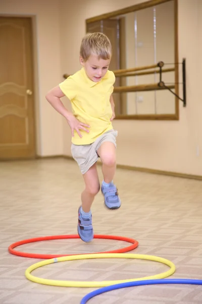 Boy makes exercise ith hoops — Stock Photo, Image