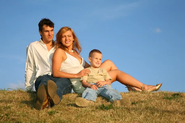 Família sentar-se no prado — Fotografia de Stock