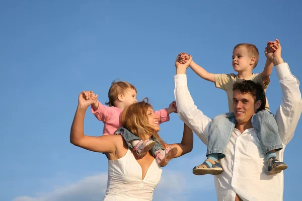 Otec a matka s dětmi na ramenou — Stock fotografie