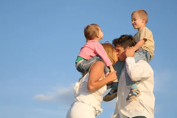 Baciare i genitori con i bambini sulle spalle — Foto Stock