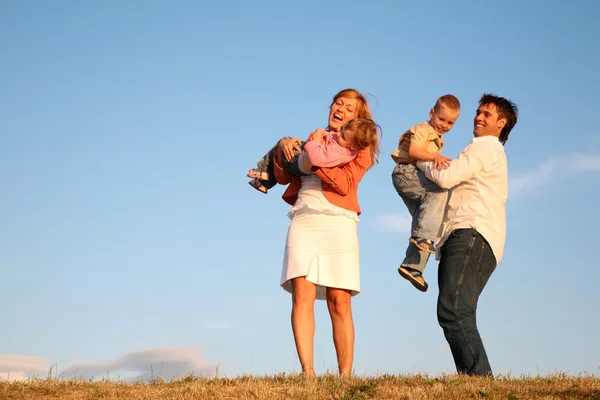 Táta a máma drží děti na rukou — Stock fotografie