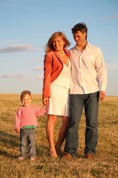 Родители стоят с ребенком на лугу — стоковое фото