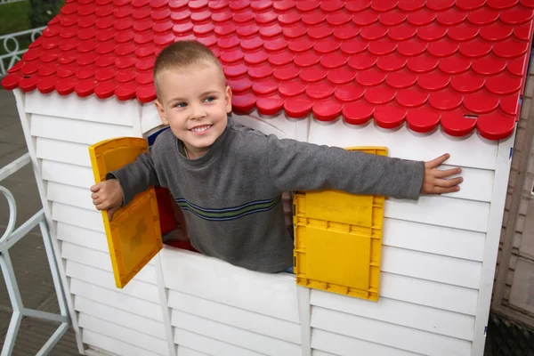 Мальчик в игрушечном домике — стоковое фото