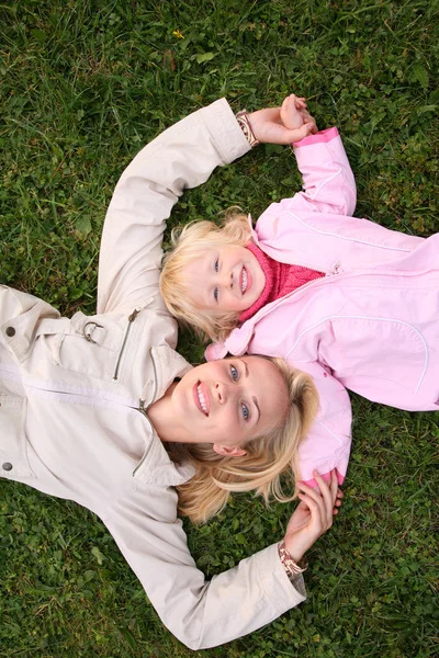 Mother and daughter lie on the grass and look upward 3 — Stock Photo, Image