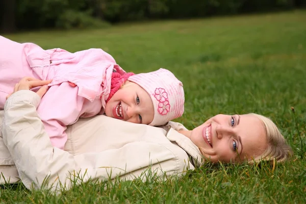 Mother lies on the grass, daughter lies on it — Stock Photo, Image