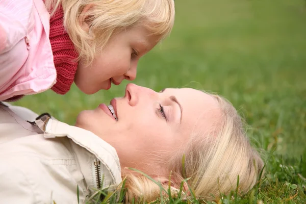 Mamma ligger på gräset, dotter ligger på det 2 — Stockfoto