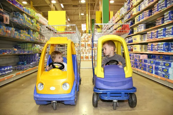 Діти в іграшкових автомобілях в магазині — стокове фото