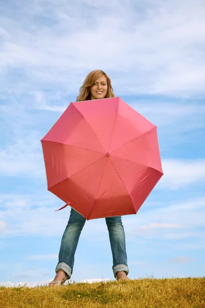 Woman with the umbrella on to the meadow — Stock Photo, Image