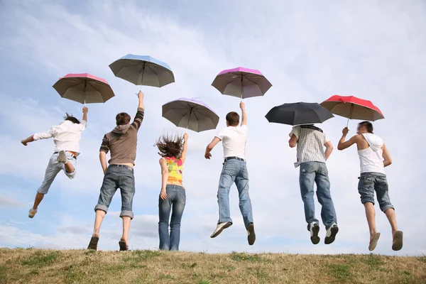Hoppning grupp med paraplyer — Stockfoto