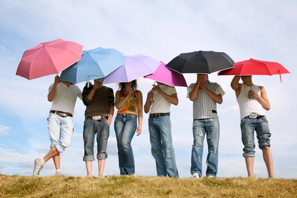 De groep van stands met de paraplu's op weide — Stockfoto
