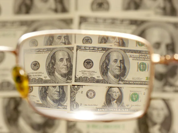 Dollar av närbild genom glasögon — Stockfoto