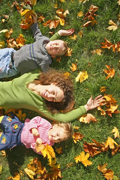 Жінка з сином і дочкою вони лежать на траві — стокове фото