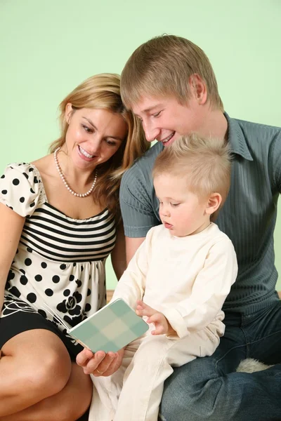Ребенок с книгой и родителями — стоковое фото