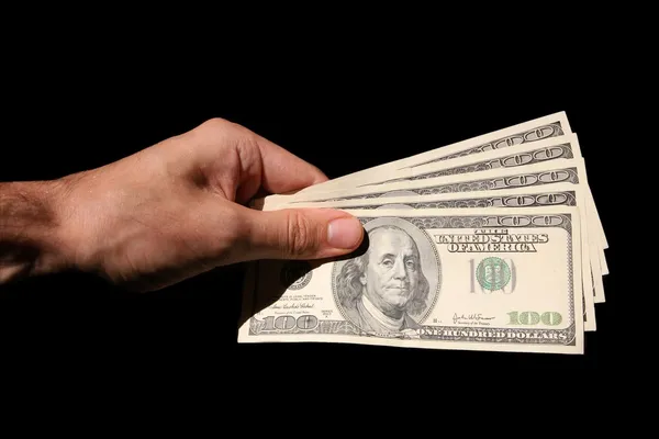 Mão e dólares isolados em fundos pretos — Fotografia de Stock