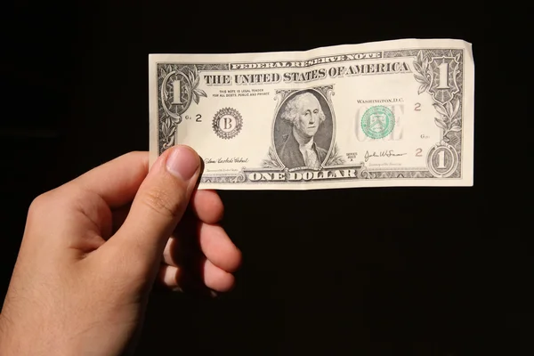 Hand und ein Dollar isoliert auf schwarzem Hintergrund 2 — Stockfoto