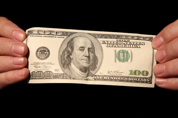 Manos y cien dólares sobre el fondo negro — Foto de Stock