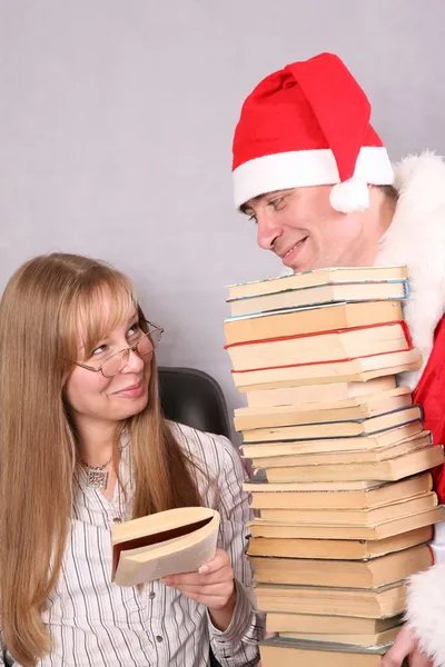 Santa claus se spoustou knih a blondýna — Stock fotografie