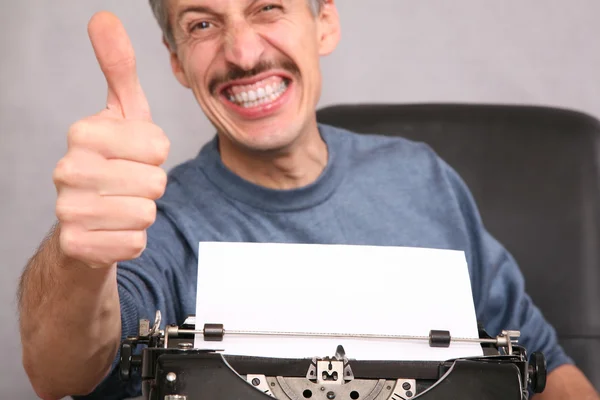 Homem após a máquina de escrever mostra gesto pelo dedo — Fotografia de Stock