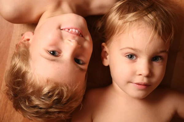 Dvě děti leží na podlaze — Stock fotografie