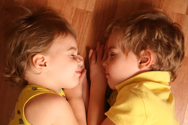 Dvě děti spát na podlaze — Stock fotografie